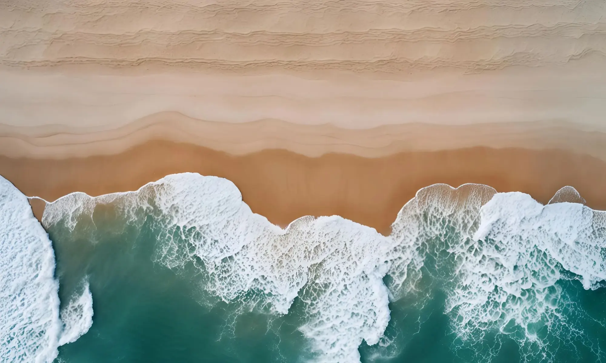 Aerial view of waves rolling onto a sandy beach