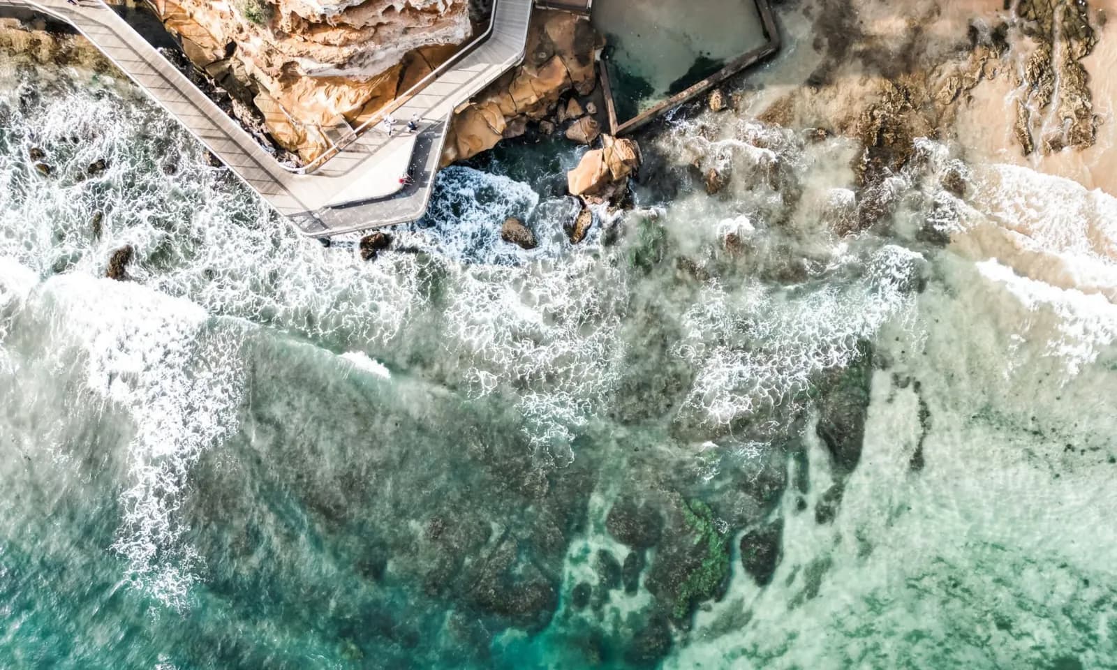 Aerial view of an ocean rock pool along a rocky coastline
